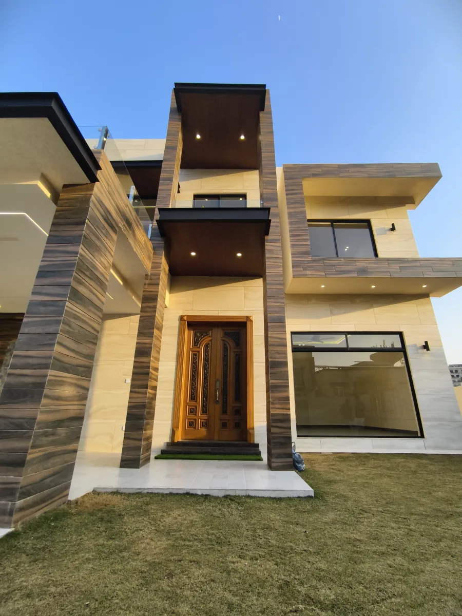 Entrance bay — carved timber door between wood-fin piers